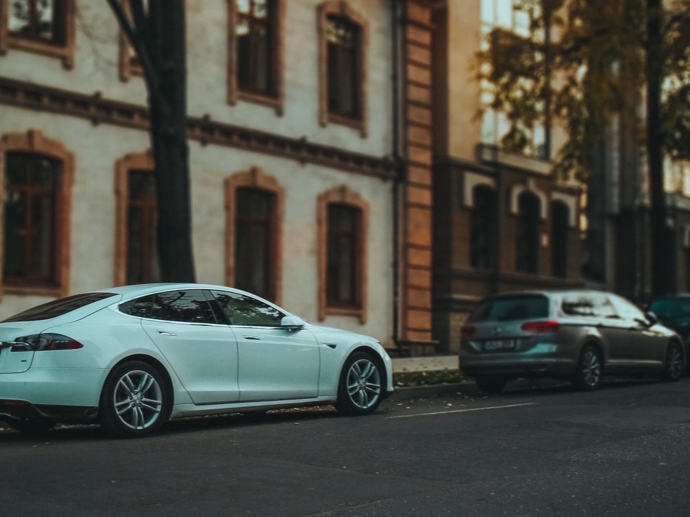 Carro sedan estacionado em uma via urbanizada